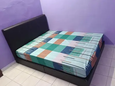 a bed with a colorful quilt on it in a room at Homestay Sayang in Ipoh