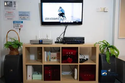 a television on a wall above a book shelf at Cozy Nanny House 2-6Pax #Georgetown #Hameediyah in George Town