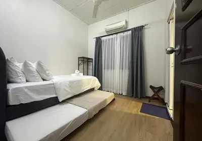 a bedroom with two beds and a window and a door at MRB Homestay in Ipoh