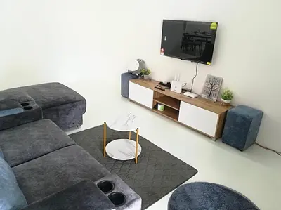 a living room with a couch and a flat screen tv at twelve homestay ipoh in Ipoh