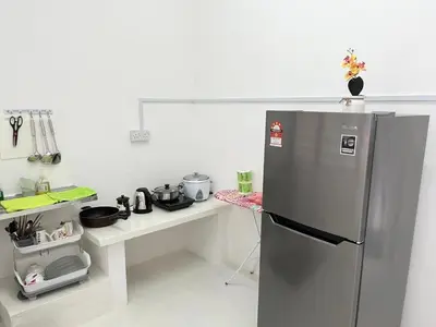 a kitchen with a stainless steel refrigerator and a counter at twelve homestay ipoh in Ipoh