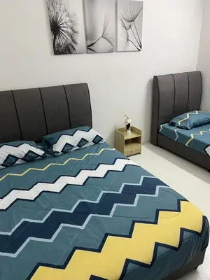 a bedroom with two beds with blue and yellow at twelve homestay ipoh in Ipoh