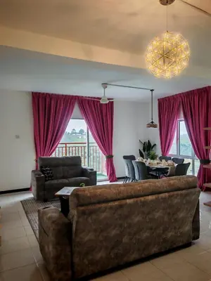 a living room with a couch and a table with chairs at ZE Emerald Avenue,Brinchang in Brinchang