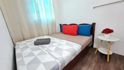 a small bedroom with a bed with colorful pillows at MediSehat KamarKu - Just 20 meters to Gleneagles Hospital Penang in George Town