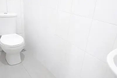 a white bathroom with a toilet and a sink at MediSehat KamarKu - Just 20 meters to Gleneagles Hospital Penang in George Town