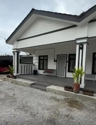 a white house with a bench in a driveway at De Bagan Village, Tanjong Karang in Tanjung Karang