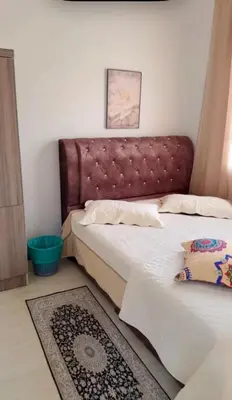 a bedroom with two beds with a headboard and a rug at De Bagan Village, Tanjong Karang in Tanjung Karang