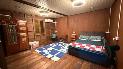 a bedroom with a bed and a wooden floor at Laman Warisan Opah Homestay in Manong