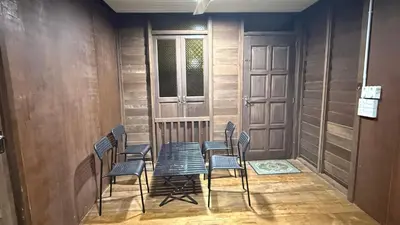 a room with chairs and a table and a door at Laman Warisan Opah Homestay in Manong