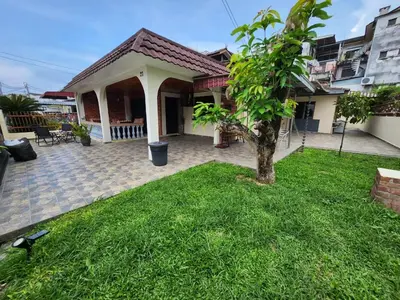 a small house with a green lawn in front of it at House of Lights in Batu Gajah