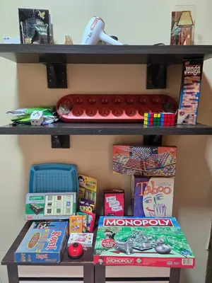 a shelf with games and other toys on it at House of Lights in Batu Gajah