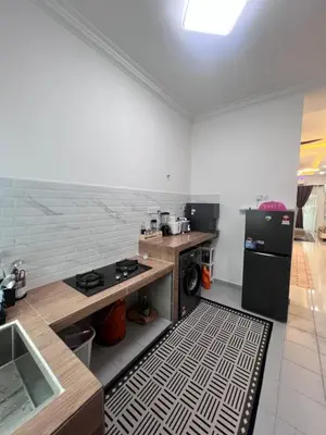 a kitchen with a stove and a refrigerator at Homestay Yunaz in Kampong Banggol Pasir