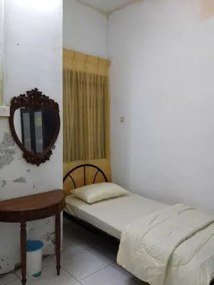 a bedroom with a bed and a mirror and a table at NORDIAZZ Home in Ipoh