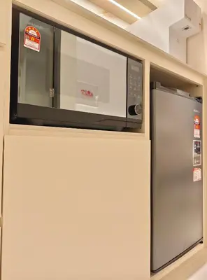 a microwave oven above a refrigerator in a kitchen at 22 Macalisterz - King Suite - 65