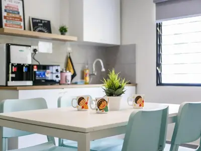 a dining room table with blue chairs and a kitchen at Cozy Corner PataniRoad 14 pax Georgetown in George Town