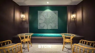 a room with two tables and a green wall at The Stallionz Premium Suites Ipoh by BYON in Ipoh