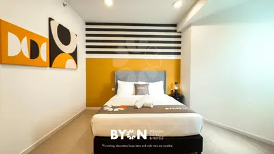 a bedroom with a bed and a striped wall at The Stallionz Premium Suites Ipoh by BYON in Ipoh