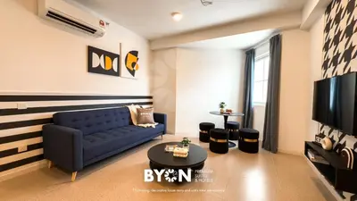 a living room with a blue couch and a tv at The Stallionz Premium Suites Ipoh by BYON in Ipoh