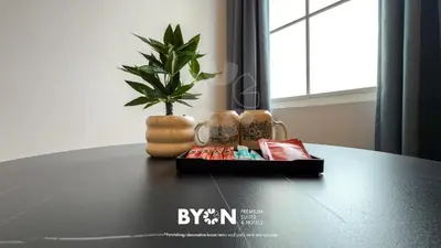 a table with a plant and a vase on it at The Stallionz Premium Suites Ipoh by BYON in Ipoh