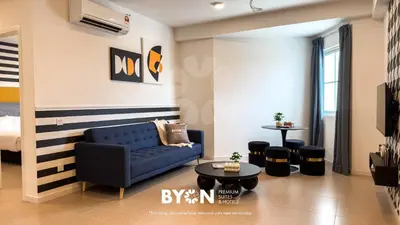 a living room with a blue couch and a table at The Stallionz Premium Suites Ipoh by BYON in Ipoh