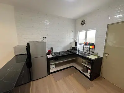 a kitchen with a black counter and a refrigerator at Rumah by Abg K in Cameron Highlands in Tanah Rata