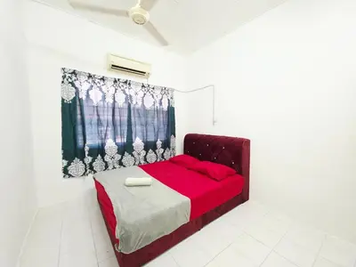 a bedroom with a red bed in a white room at Homestay Taman Segar 23 for musleem in TanjongMalim