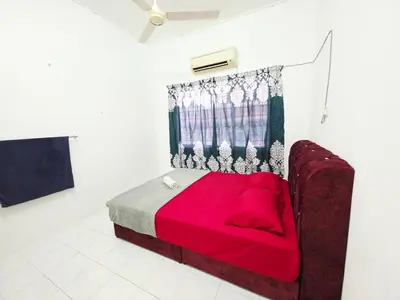 a bedroom with a bed with a red blanket at Homestay Taman Segar 23 for musleem in TanjongMalim