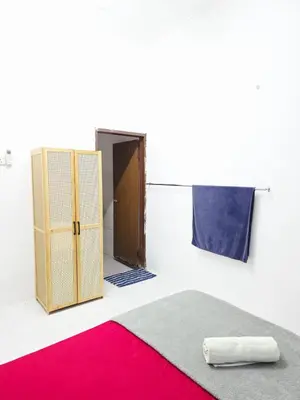 a room with a bed and a door and a red rug at Homestay Taman Segar 23 for musleem in TanjongMalim