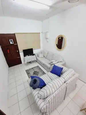 a living room with a couch and blue pillows at Homestay Taman Segar for musleem in TanjongMalim