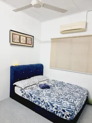 a bed with a blue headboard in a room at Homestay Taman Segar for musleem in TanjongMalim