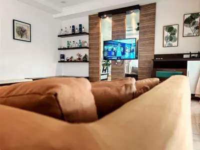 a living room with a couch and a flat screen tv at 10paxx HotSprings Recovery Stay in Ipoh