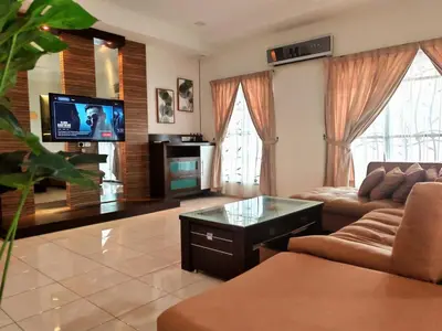 a living room with a couch and a flat screen tv at 10paxx HotSprings Recovery Stay in Ipoh