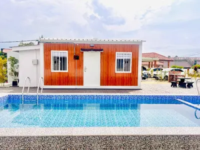 a small house with a pool in front of it at Rossaliya Cottage in Taiping