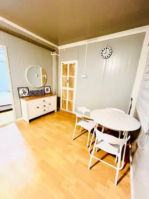 a dining room with a white table and chairs at Rossaliya Cottage in Taiping