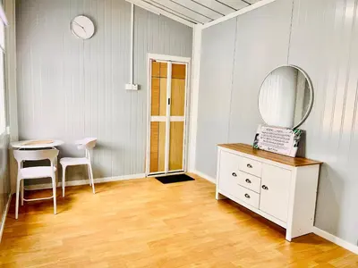 a room with a mirror and a dresser and a table at Rossaliya Cottage in Taiping