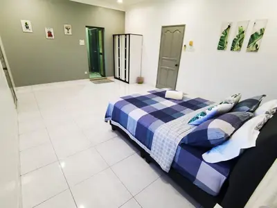 a bedroom with a bed with a blue plaid blanket at Spacious 4BR Corner with Pool Table in Ipoh