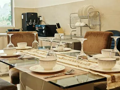 a table with plates and wine glasses on it at 16 Paxx Mountain Joy Corner Villa with KTV Pool BBQ in Ipoh