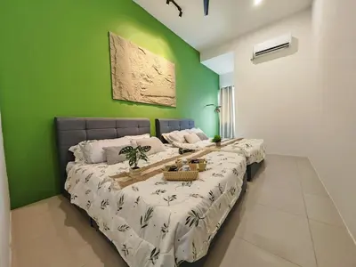 two beds in a room with a green wall at 16 Paxx Mountain Joy Corner Villa with KTV Pool BBQ in Ipoh