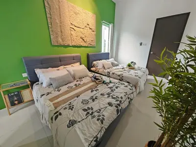 two beds in a room with green walls at 16 Paxx Mountain Joy Corner Villa with KTV Pool BBQ in Ipoh