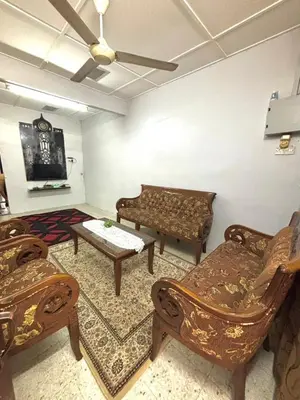 a living room with chairs and a couch and a table at Budi Homestay Taman Jati in Ipoh