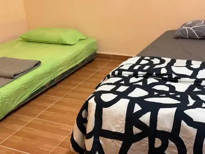 two beds sitting next to each other in a room at Bidor Bonda Homestay in Bidur