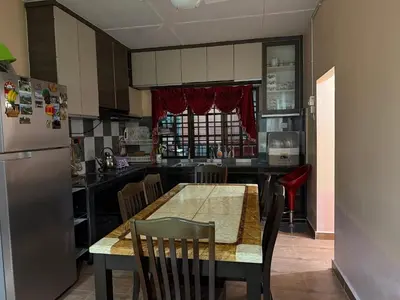 a kitchen with a table with chairs and a refrigerator at Bidor Bonda Homestay in Bidur