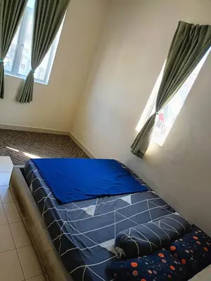 a bedroom with a blue bed with two windows at A&M Homestay Prima Bagan Serai in Bagan Serai