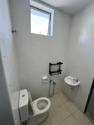a white bathroom with a toilet and a sink at A&M Homestay Prima Bagan Serai in Bagan Serai