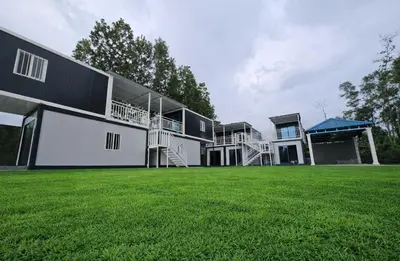 a large building with a grass field in front of it at Galaxy Homestay in Ipoh