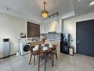 a kitchen with a table and a black refrigerator at Le Cozy Cabin - 2B2R SeaCity View Infinity Pool in George Town