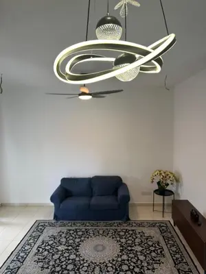 a living room with a blue couch and a chandelier at Eryna Homestay in Nibung Tebal