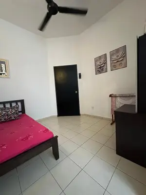 a bedroom with a red bed and a black door at Eryna Homestay in Nibung Tebal
