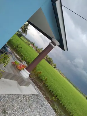a blue umbrella sitting on the side of a field at Aziyaa Homestay rumah no1 in Sungai Besar