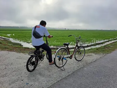 a man riding a bike on the side of a road at Aziyaa Homestay rumah no1 in Sungai Besar